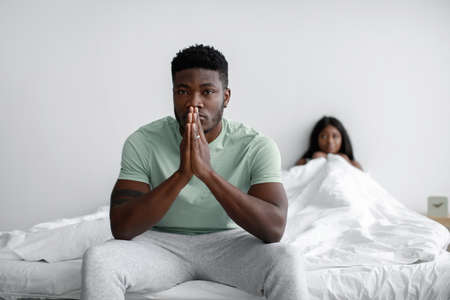 Frustrated depressed young african american male is sad, thinking and ignoring woman after quarrel,...