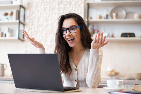 Portrait of excited woman making online video call, talking with colleagues or clients via laptop,...