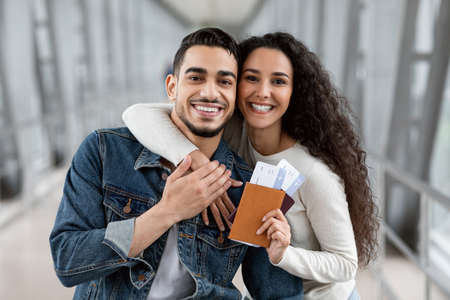 Joyful Millennial Arab Spouses With Passports And Tickets In Hands At Airportの写真素材