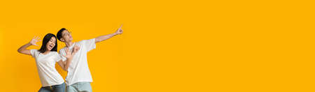Wide Horizontal Banner With Joyful Asian Couple Dancing Over Yellow Background