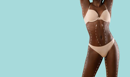 Beautiful black lady posing in beige underwear on blue, cropped