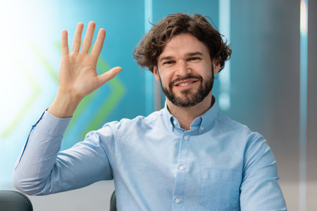 Greeting Concept. Smiling business man waving hand at camera