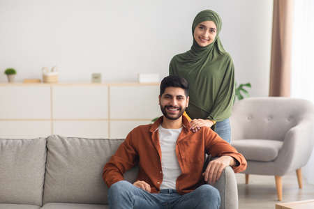 Happy Married Muslim Couple Posing At Home, Smiling To Cameraの写真素材