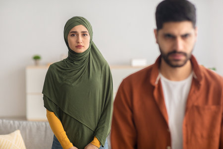 Unhappy Muslim Wife Standing Behind Husbands Back At Homeの写真素材