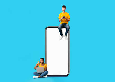 Couple sitting on white empty smartphone screen and using gadgets