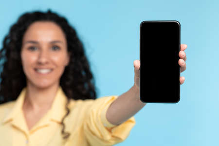 Closeup of lady holding showing black empty smart phone screen