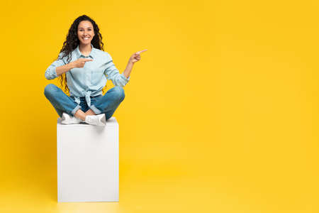 Excited woman pointing aside at copy spaceの写真素材