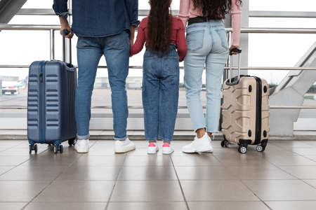 Parents And Little Daughter Waiting In Airport With Suitcases, Rear Viewの写真素材