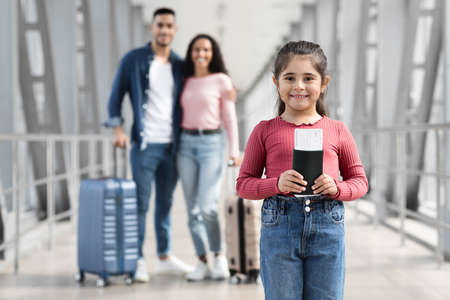 Cute Little Girl Posing At Airport While Travelling With Parentsの写真素材