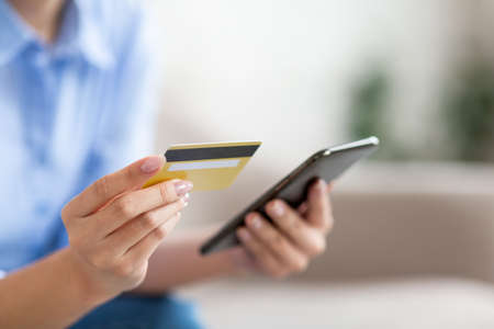 Unrecognizable lady holding smartphone and credit card