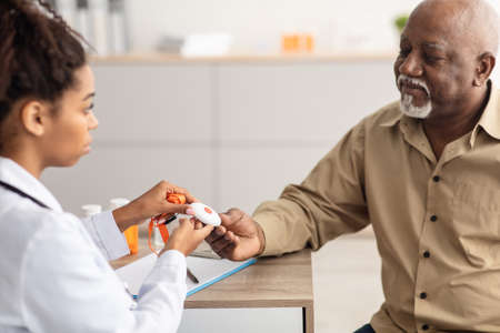 Emergency call system. Doctor giving Alarm Button to Senior Man