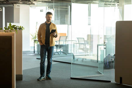 Cheerful Businessman Using Digital Tablet Computer Entering Modern Office