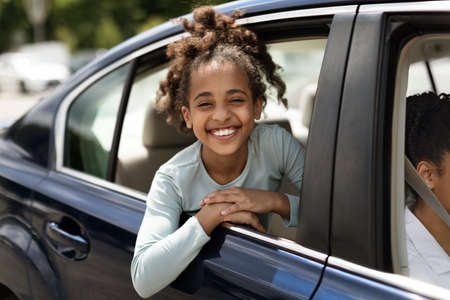 Happy Black Kid Girl Looking Out Of Car Window