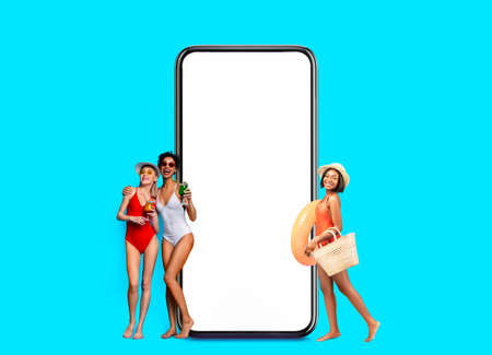 Summer Party. Group Of Multiethnic Women In Swimsuits Posing Near Blank Smartphoneの写真素材