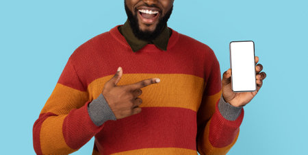 Smiling Black Man Pointing At Blank Cellphone With White Screen In Handの写真素材