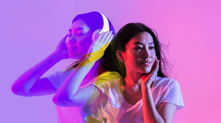 Attractive asian woman dreaming about new wireless headphones