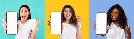 Pretty multiracial ladies showing smartphones with empty screens