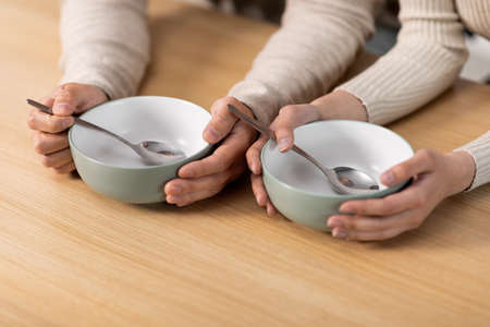 Unrecognizable people sitting at table with empty platesの写真素材