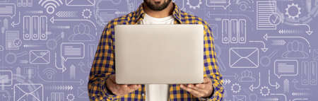 Unrecognizable Man With Laptop Standing Over Purple Background With Abstract Media Icons
