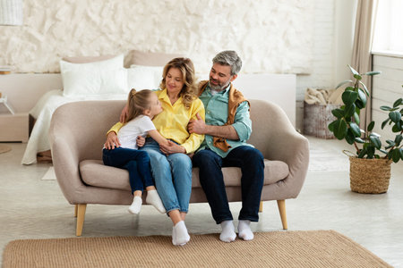 Family Spending Time Together Sitting On Sofa At Home