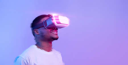 Excited black man wearing vr glasses looking at copy spaceの写真素材