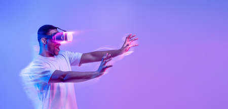 Amazed black man in VR headset, panorama with copy space