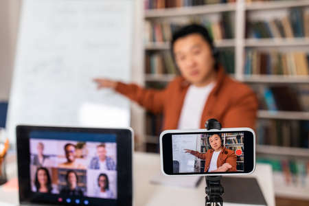 Japanese Teacher Filming Online Lecture On Cellphone And Laptop Indoor
