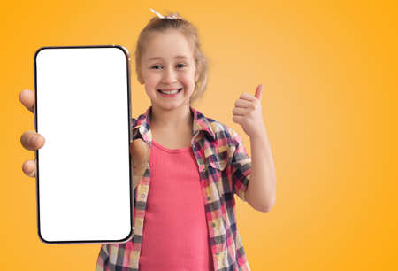 Cute Happy Little Girl Holding Big Blank Smartphone And Showing Thumb Up