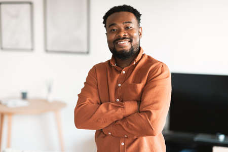 Cheerful African American Man Posing Crossing Hands Standing At Home