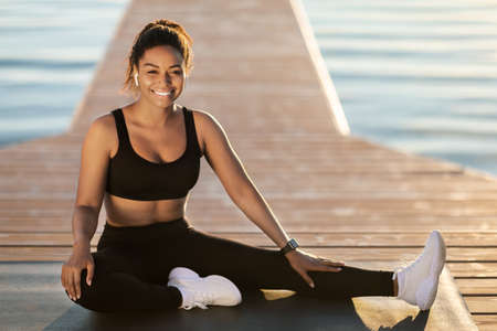 Happy pretty black woman posing while exercising outdoor