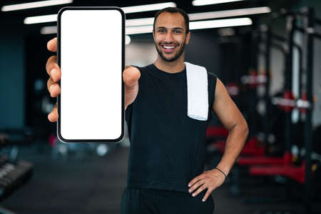 Fitness App. Sporty Black Guy Showing Smartphone With Blank White Screen