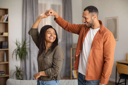 Cheerful Black Spouses Dancing Having Fun Together Indoorsの写真素材