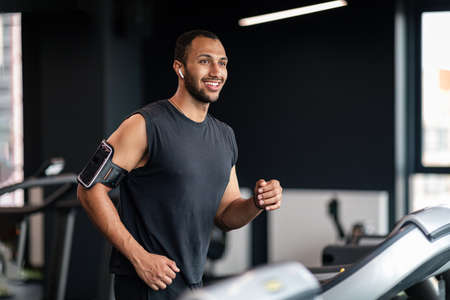Portrait Of Handsome Male Athlete Exercising On Treadmill At Gym