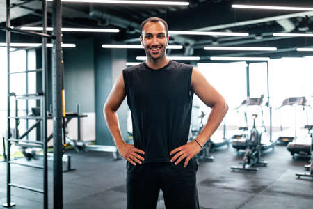 Portrait Of Handsome Black Personal Trainer Posing In Fitness Club Interiorの写真素材