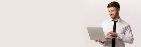 Advertisement Banner With Handsome Businessman Using Laptop While Standing Over White Background