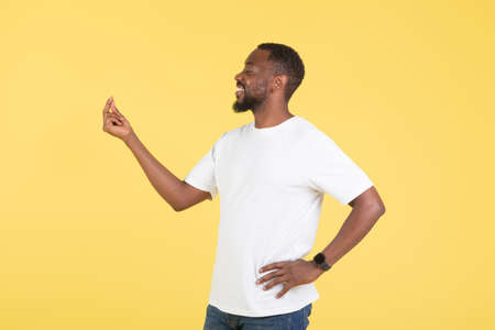 African American Male Doing Finger Snap Gesture Over Yellow Backgroundの写真素材