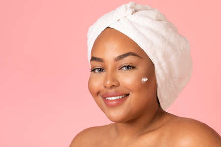 Black Woman Posing With Moisturizer Dots On Face, Pink Background