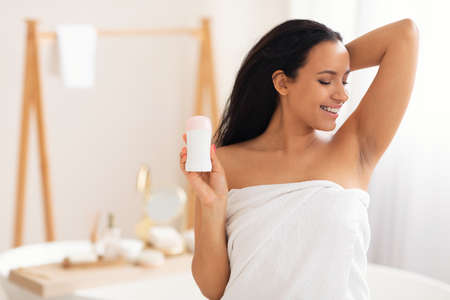 Happy Millennial Woman Holding Antiperspirant Stick Standing In Modern Bathroom