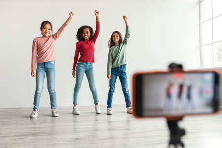 Three Diverse Blogger Girls Making Video On Smartphone Indoorsの写真素材