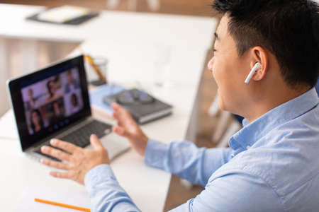 Korean Male Teacher Having Video Call Via Laptop At Workplace