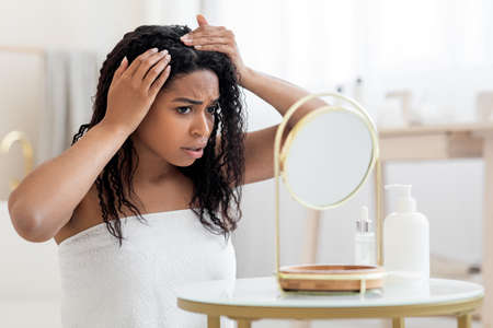 Dandruff Problem. Upset African American Female Looking To Mirror At Hair Rootsの写真素材