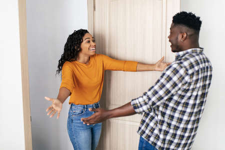 African Woman And Man Stretching Hands For Hug Meeting Indoorsの写真素材
