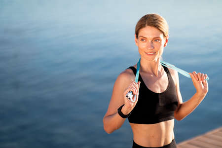 Beautiful Middle Aged Woman In Sportswear Posing With Skipping Rope Outdoors