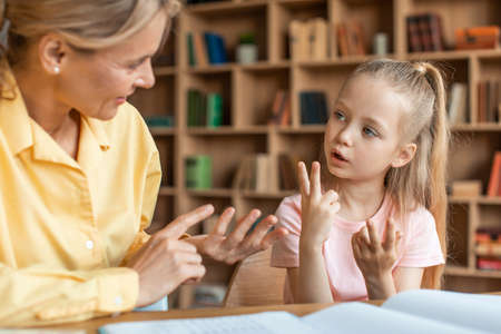 Pretty little girl counting on fingers at private teachers office, kid learning the numbers and how...