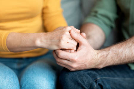 Cropped Shot Of Loving Middle Aged Couple Holding Hands Together
