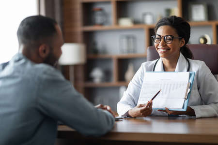 African american man visiting female doctor at clinicの写真素材