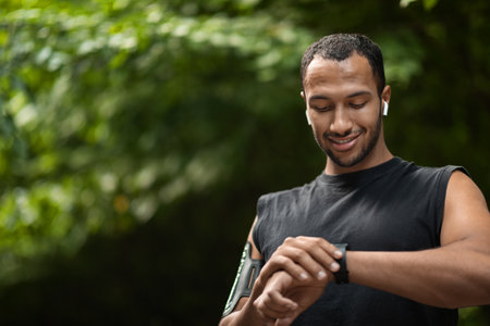 Handsome young black sportsman set his fitness tracker