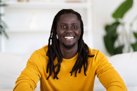 Portrait Of Smiling Young Black Male Posing In Home Interior