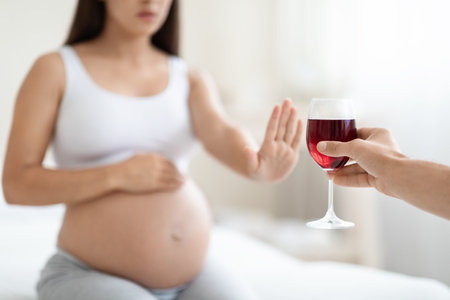 Cropped of young pregnant woman refuses to drink wineの写真素材