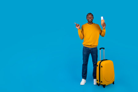 Happy black man having journey, pointing at copy spaceの写真素材